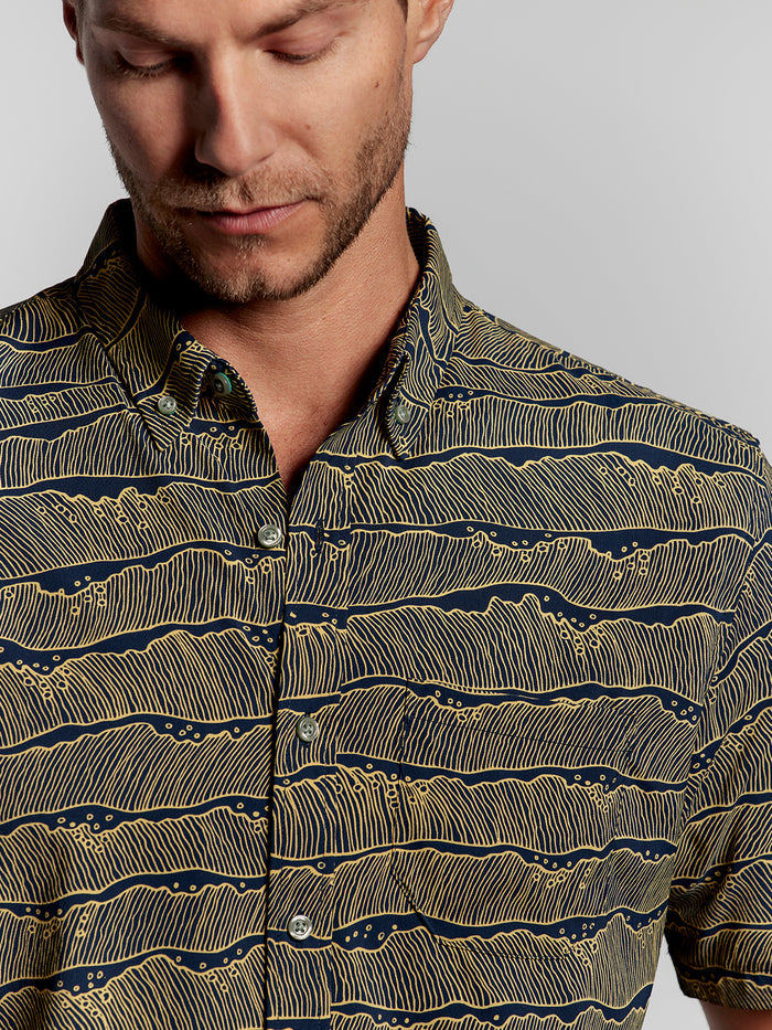 Midnight solid short-sleeve shirt, close-up shoulders up, man looking down.