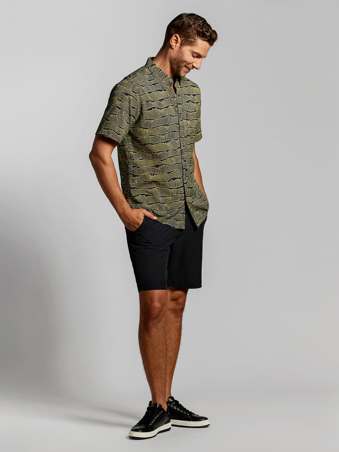 Midnight short-sleeve shirt and black shorts, front view with hands in pockets.