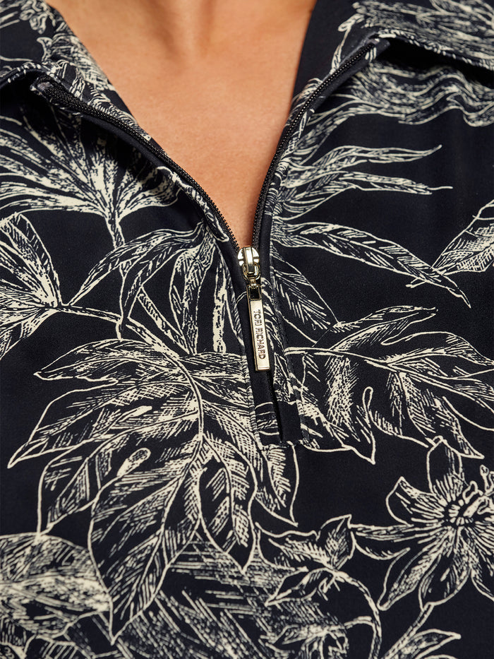 Black and white botanical-print dress, close-up of zipper collar.