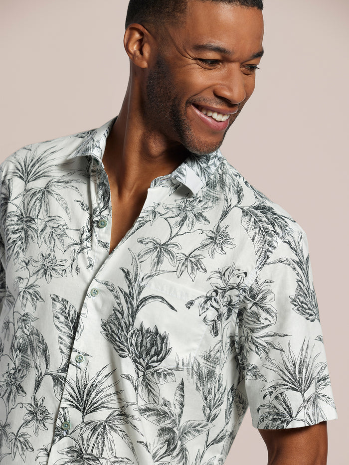 White shirt with black botanical print, cotton lawn fabric, side view of man smiling