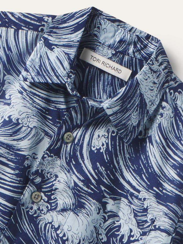 Blue and white wave-print short-sleeve shirt, front view with collar and buttons.