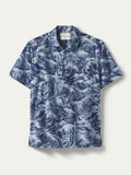 Blue and white wave-print short-sleeve button-up shirt, front view, on plain background.