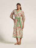 Pink floral cotton caftan dress with green trim and sash, shown on model, front view.