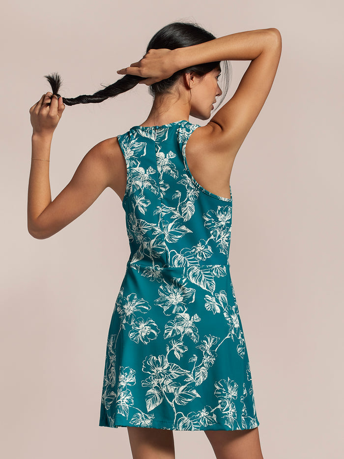 Teal floral-print romper, back view, model holding up braided hair.