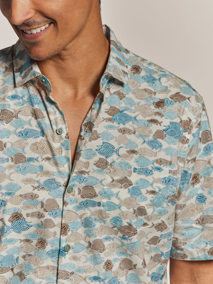 Off-White Hawaiian Blue and brown fish-print cotton button-up shirt, partial front view showing lower face and torso.