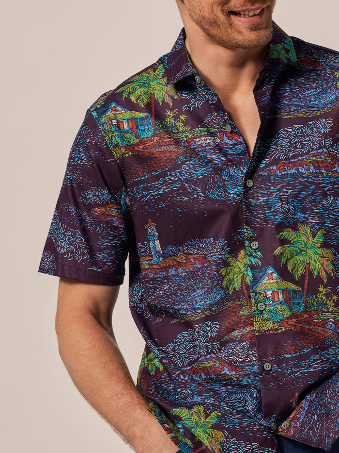 Navy blue tropical huts and palms print short-sleeve shirt, front view in lightweight cotton lawn.