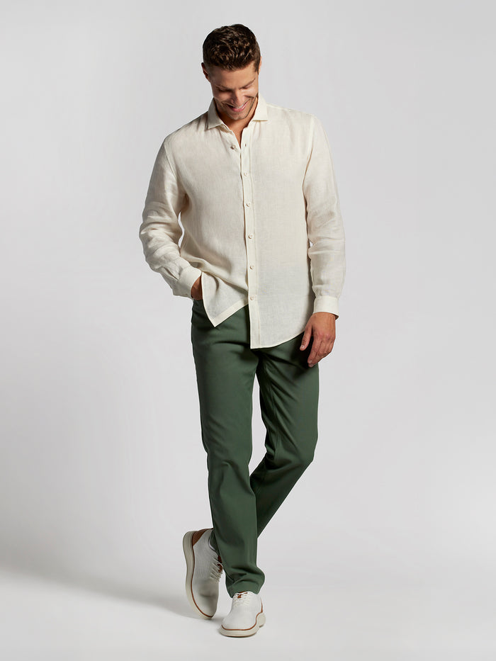 Beige button-up shirt, green solid pants, and white shoes, full front view.