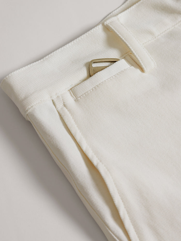 Whiite shorts close-up with metal key partly visible in front pocket.