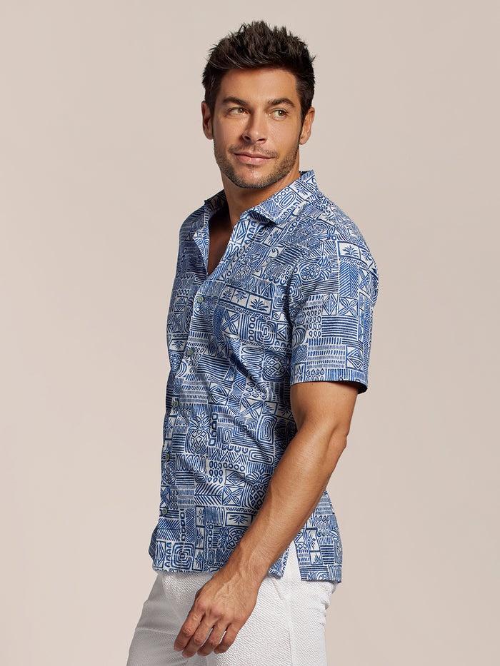 Blue floral-print cotton Hawaiian shirt and white shorts, left side view, plain background.