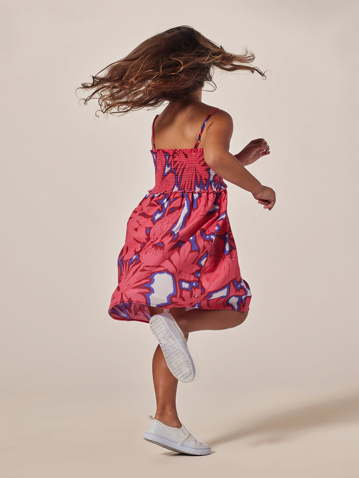 Multicolor ikat-print dress with smocked bodice, twirling back view.