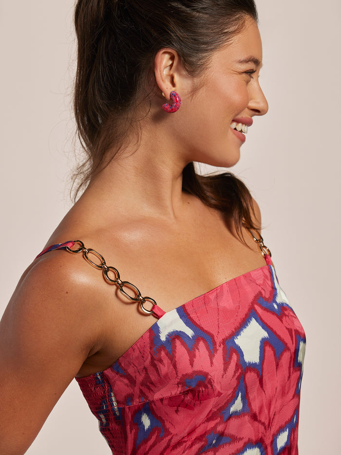 Pink ikat-print sleeveless dress with gold chain straps, right side view.