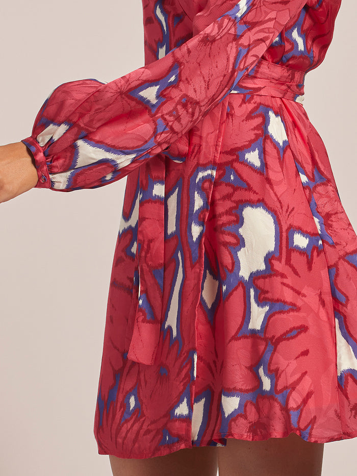 Multicolored ikat-pattern Maryam dress; wearer in side view with left arm extended .