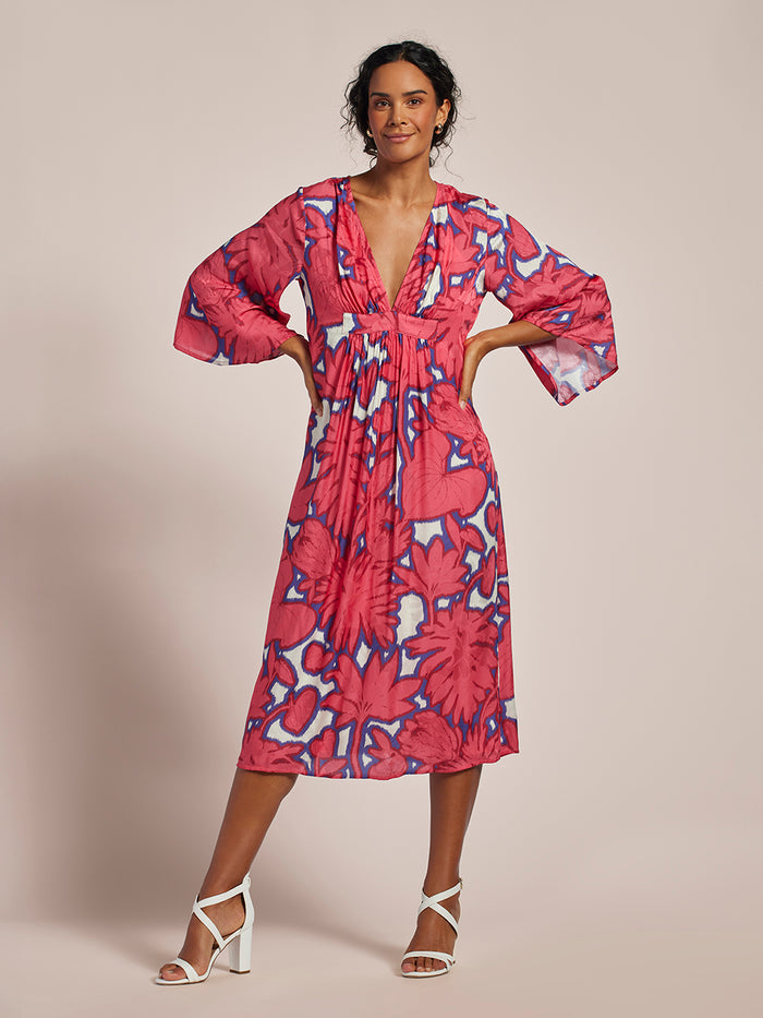 Pink floral-print caftan with blue accents and v-neckline, full-length front view.