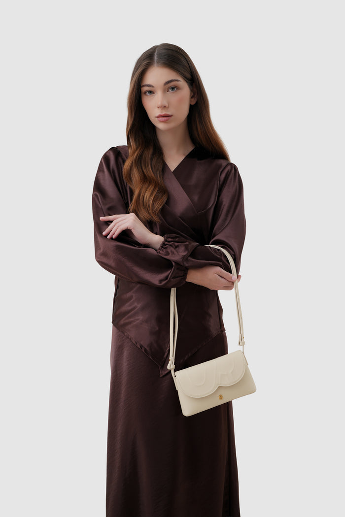 jenny sling bag in beige by buttonscarves on wrist carry style