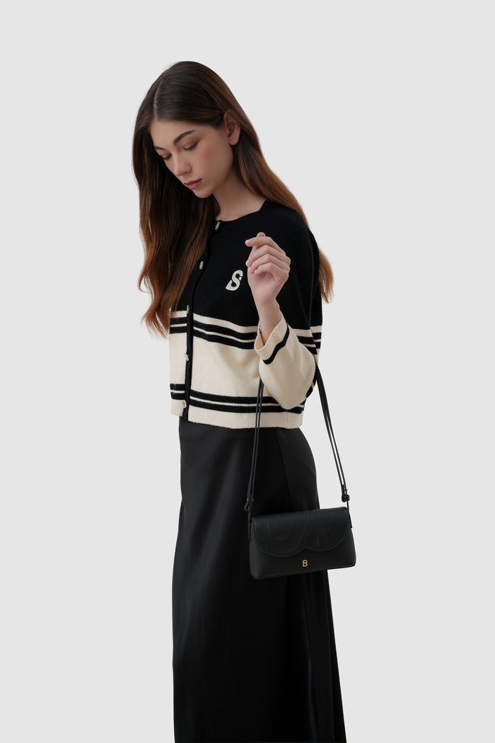 jenny sling bag in black by buttonscarves on wrist carry style