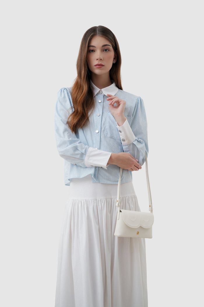 jenny sling bag in broken white by buttonscarves on wrist carry style