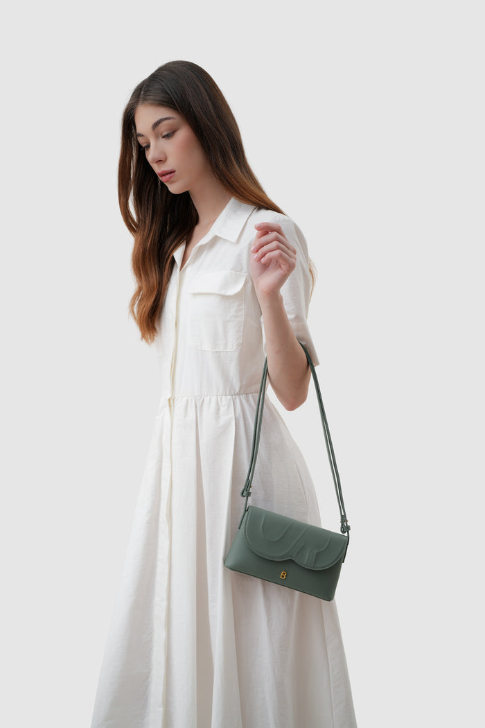 jenny sling bag in slate green by buttonscarves on wrist carry style