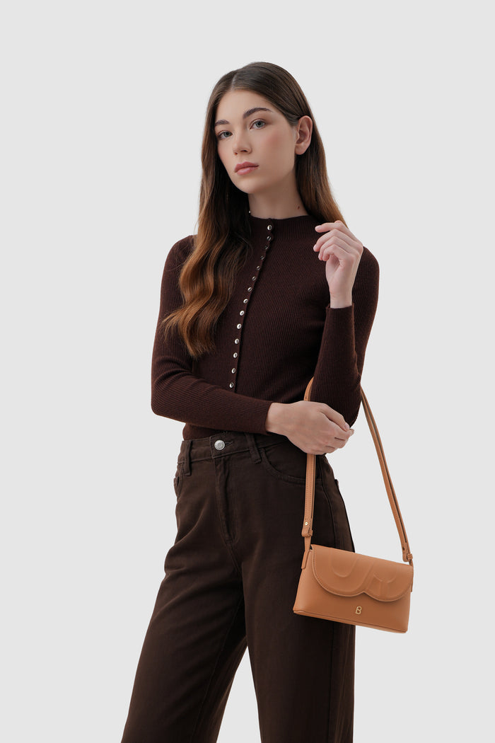 jenny sling bag in tan by buttonscarves on wrist carry style