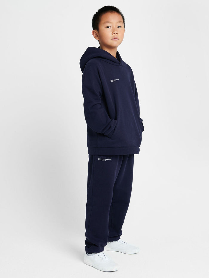 Kids' 365 Midweight Hoodie in navy and matching organic cotton sweatpants on boy. Boxy, oversized fit, hooded