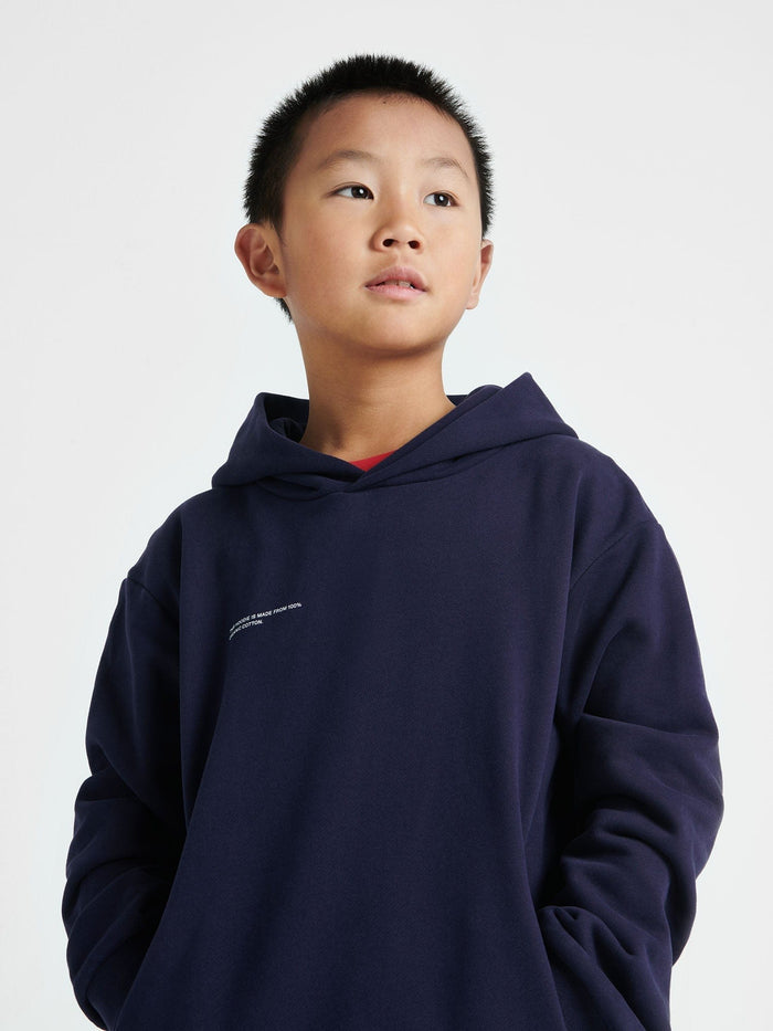 Young boy in a navy Kids' 365 Midweight Hoodie Crafted from 320 GSM organic cotton with an oversized boxy fit