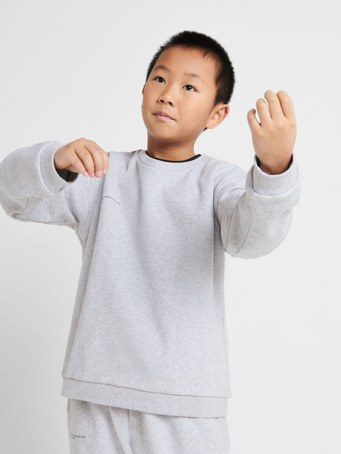 Boy wearing grey marl Kids' 365 Midweight Sweatshirt. 320 GSM organic cotton, oversized genderless fit, crew neck