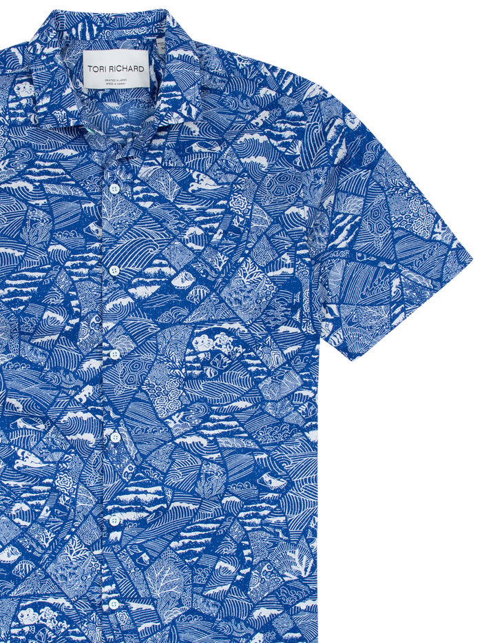 Navy and white tropical leaf, wave-mosaic print short-sleeve button-up shirt Front view of blue and white geometric and nature-print cotton shirt.