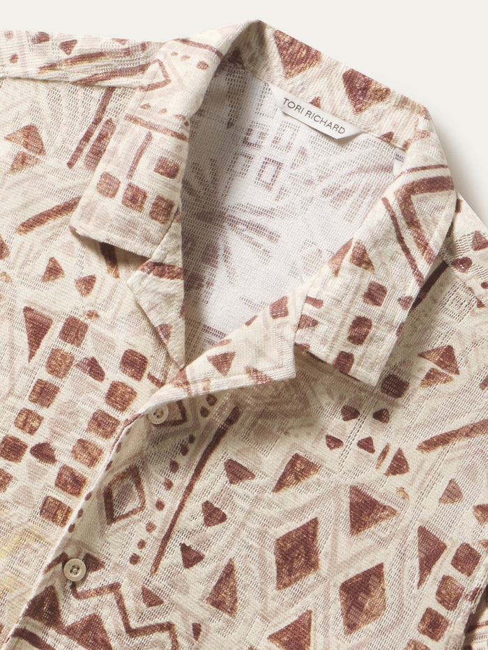 Beige and brown geometric jacquard knit shirt, close-up of front buttons.