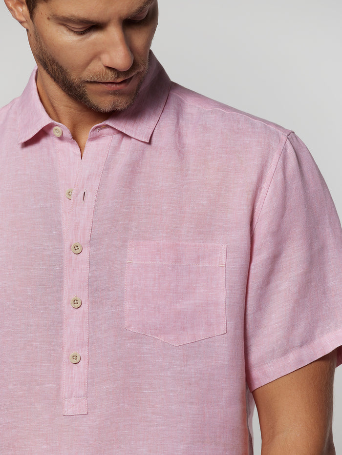 Light pink solid half placket shirt, man looking down with hands in pockets, front view (Images 1 & 2).