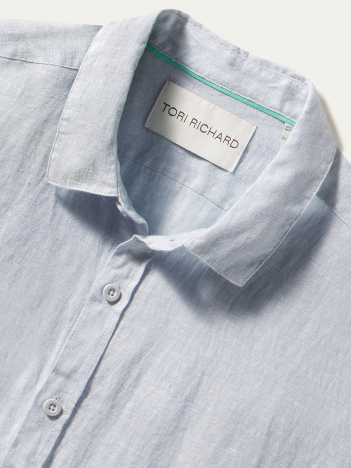 Light blue solid long-sleeve shirt, front view on a white background, label visible inside.