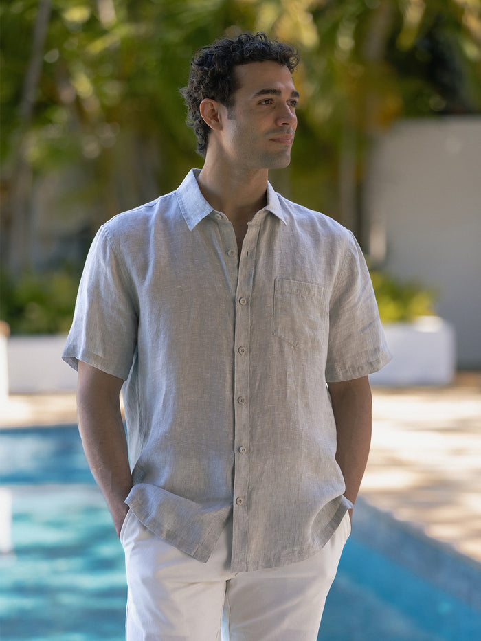 Kona light blue slub linen short-sleeve shirt and white pants, front and side views by a sunlit pool.