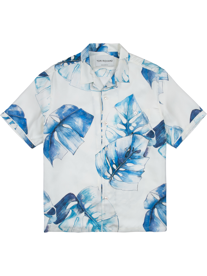 Blue tropical leaf short-sleeve button-up shirt, sand-washed twill, flat lay view.