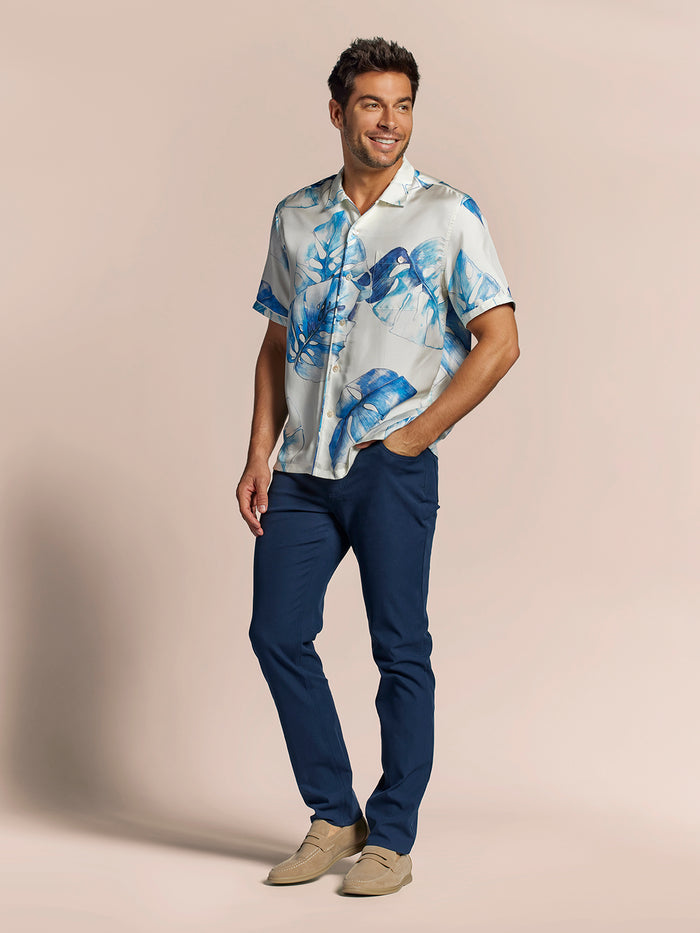 White and blue leaf-print short-sleeve shirt, navy pants; full front view
