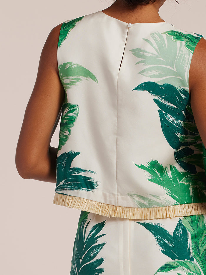 Green leaf-print top with raffia fringe, back view.
