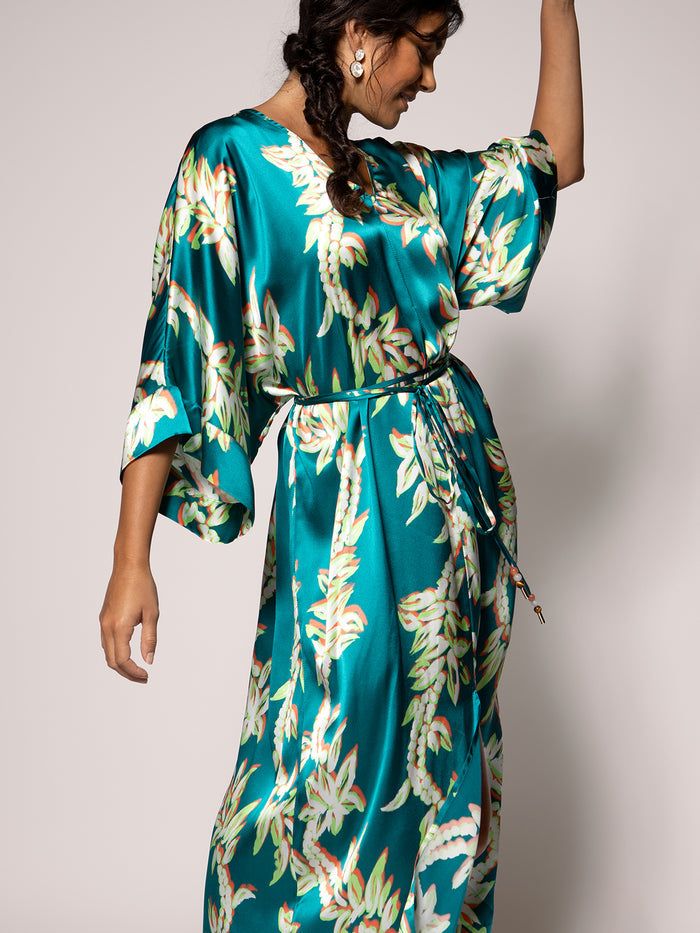 Teal floral-print Calliope dress with waist tie, side view, with flowing fabric detail.