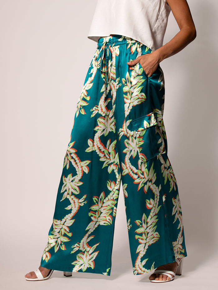 White/green floral pants, model front view, hand in pocket.