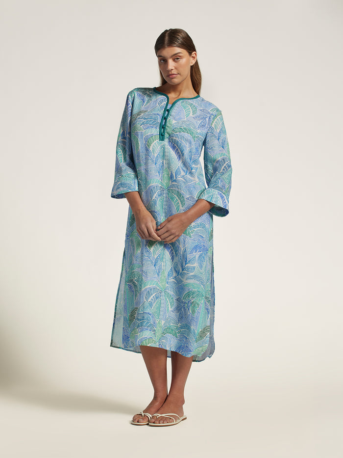 Woman wearing a blue-green patterned dress on a white background