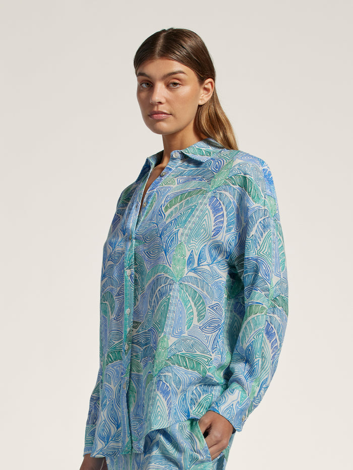 Blue and green geometric-patterned linen oversized top, front view on light background.
