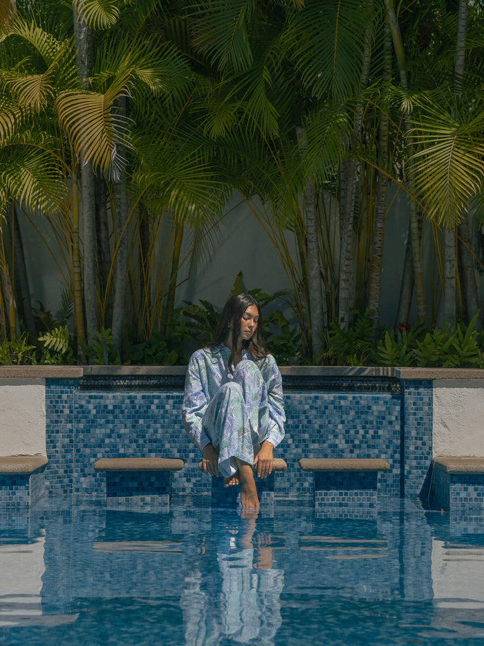 Teal and white abstract-print sleeveless top, poolside view with foot in water (Images 1 & 2).
