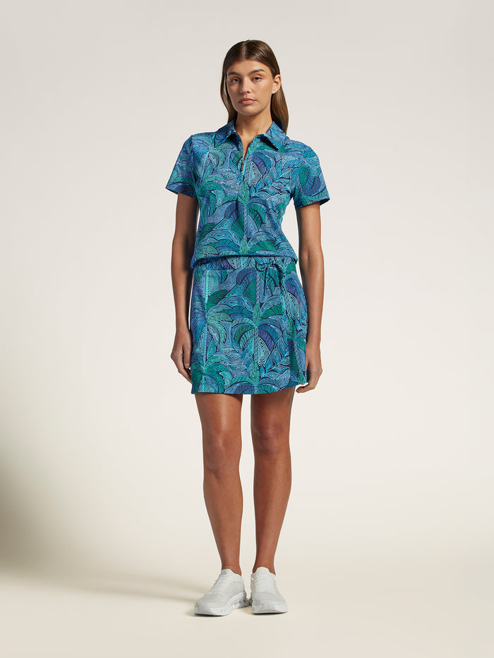 Blue and green leaf-patterned slim-fit polo shirt, front view on plain background.