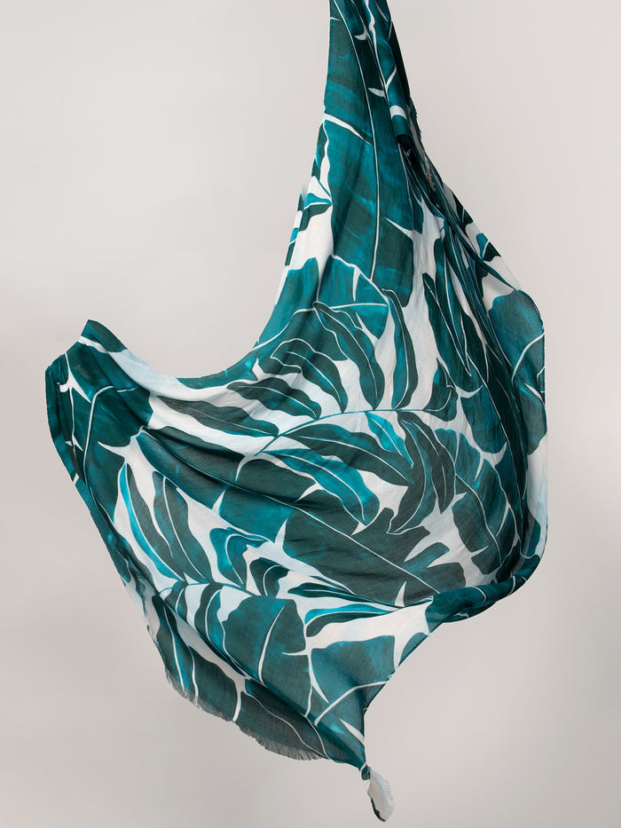 Green and white banana leaf-print scarf, draped view against a neutral background.
