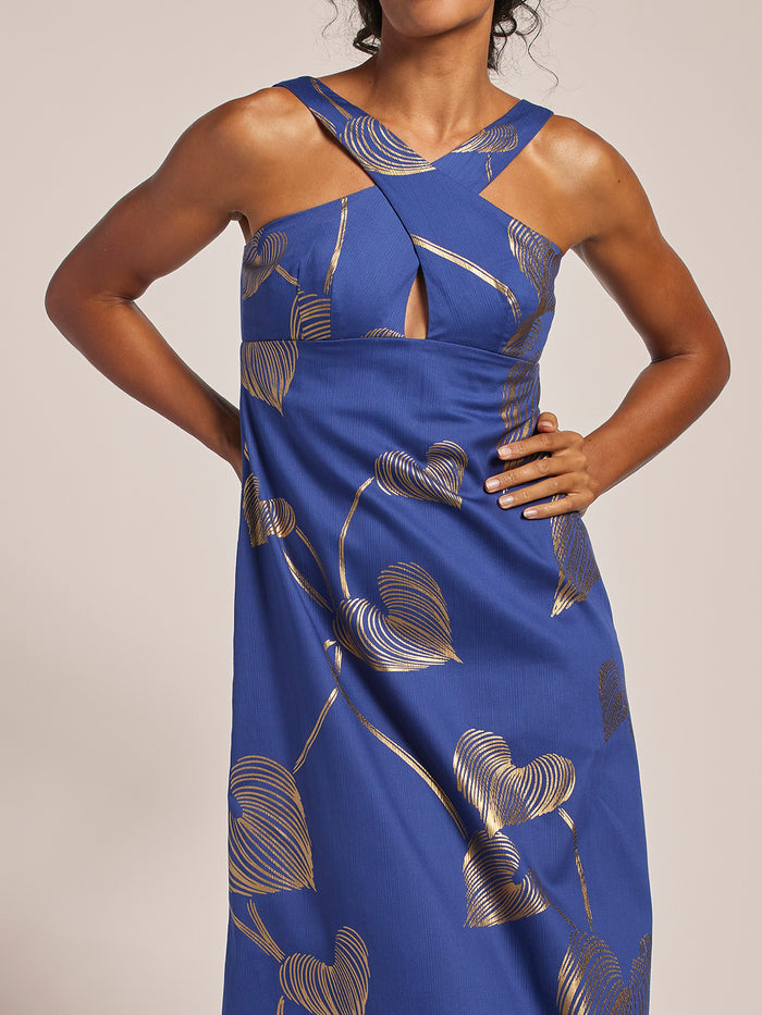 Blue metallic, gold leaf-print maxi dress with cross-halter neck and keyhole cutout, front view.