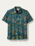 Blue-green jungle print short-sleeve shirt on white background, front view.