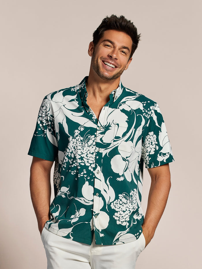 Dark green/white bold floral short-sleeve Hawaiian shirt,  front view with white pants shown in both images.