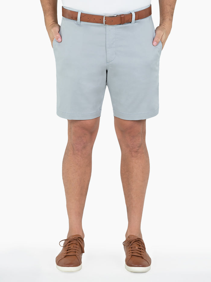Light blue shorts, brown belt, white sneakers, front view. Hands in pockets.