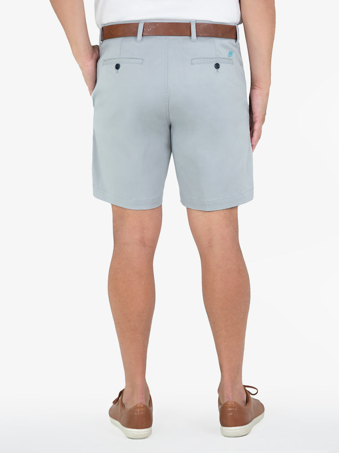 Light blue solid cotton-blend shorts with brown belt and loafers, rear view.