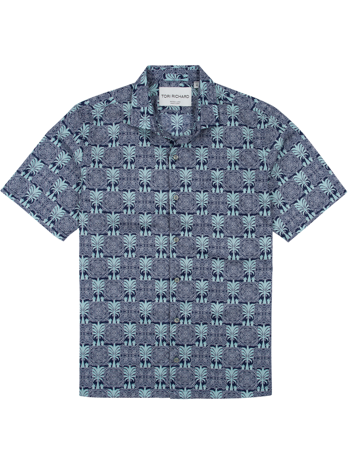 White short-sleeve button-up shirt with blue palm print, flat lay front view.