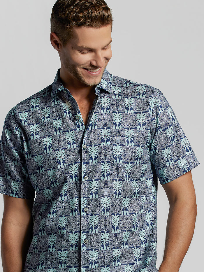Gray short-sleeve shirt with blue palm tree print in lightweight cotton, shown from the front.