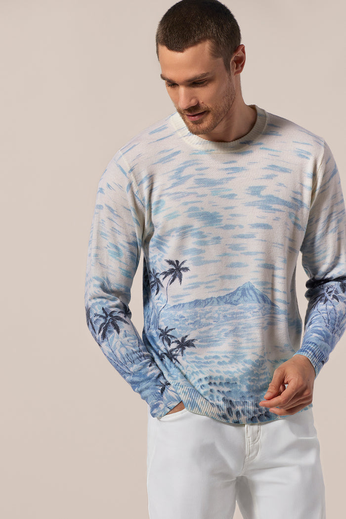 Blue ocean patterned long sleeve sweater with white pants, straight-on.