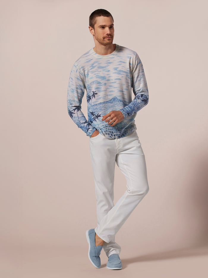 Blue graphic sweater, white pants, blue shoes, front view.