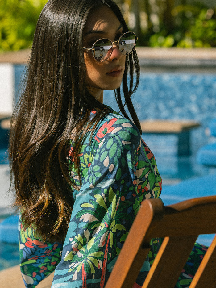 Green opalescent caftan with multicolor floral print, poolside, side view.